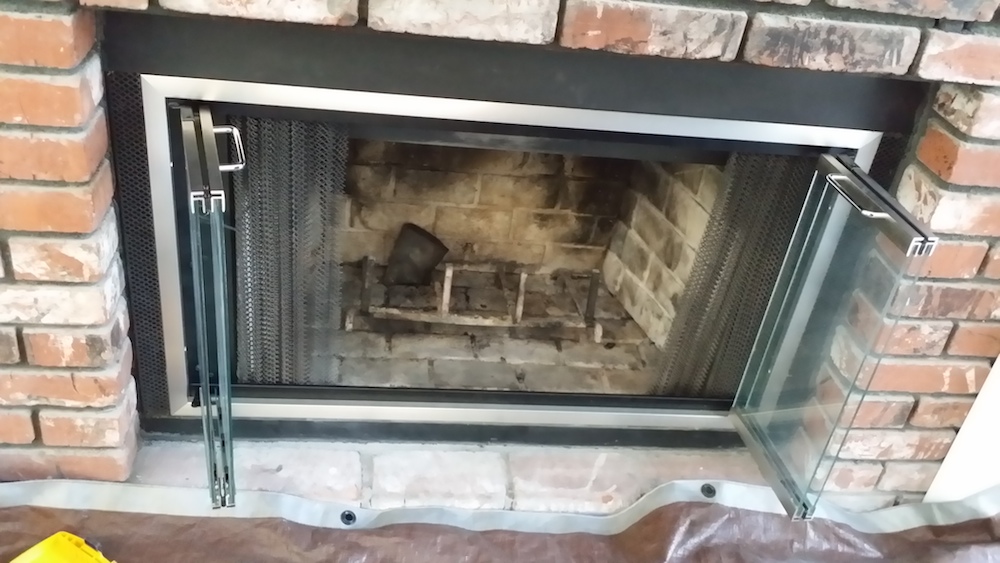 These 2 pictures are a set of custom made satin nickel finished fireplace glass doors. Gives a very nice contemporary look to an old fireplace.